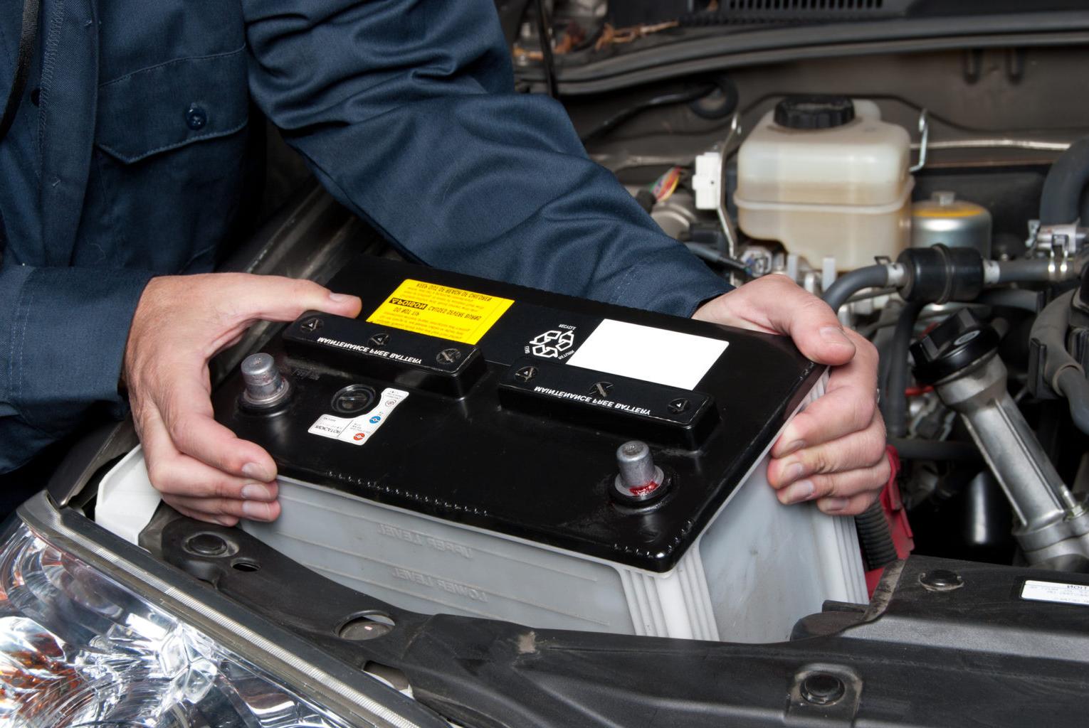 Auto mechanic installing a car battery